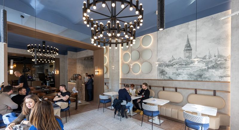 Fabrika dining room: chandeliers, blue ceiling and a drawing of old Subotica on the wall