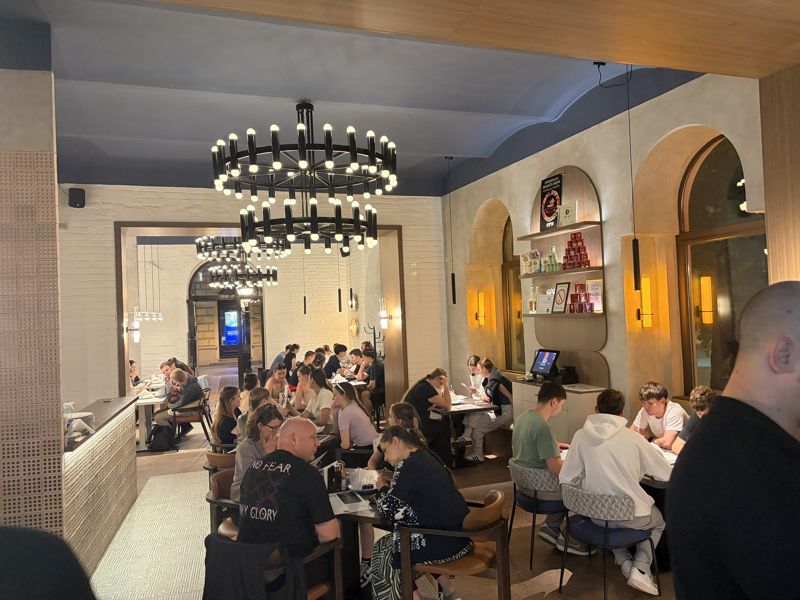 The restaurant full in the evening: chandeliers, a blue ceiling and guests at their tables
